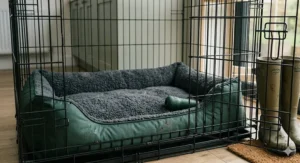 A high-resolution 4K close-up photograph capturing a rugged, dark green waterproof and orthopaedic bolster dog bed perfectly fitted inside a black wire dog crate from Amazon.